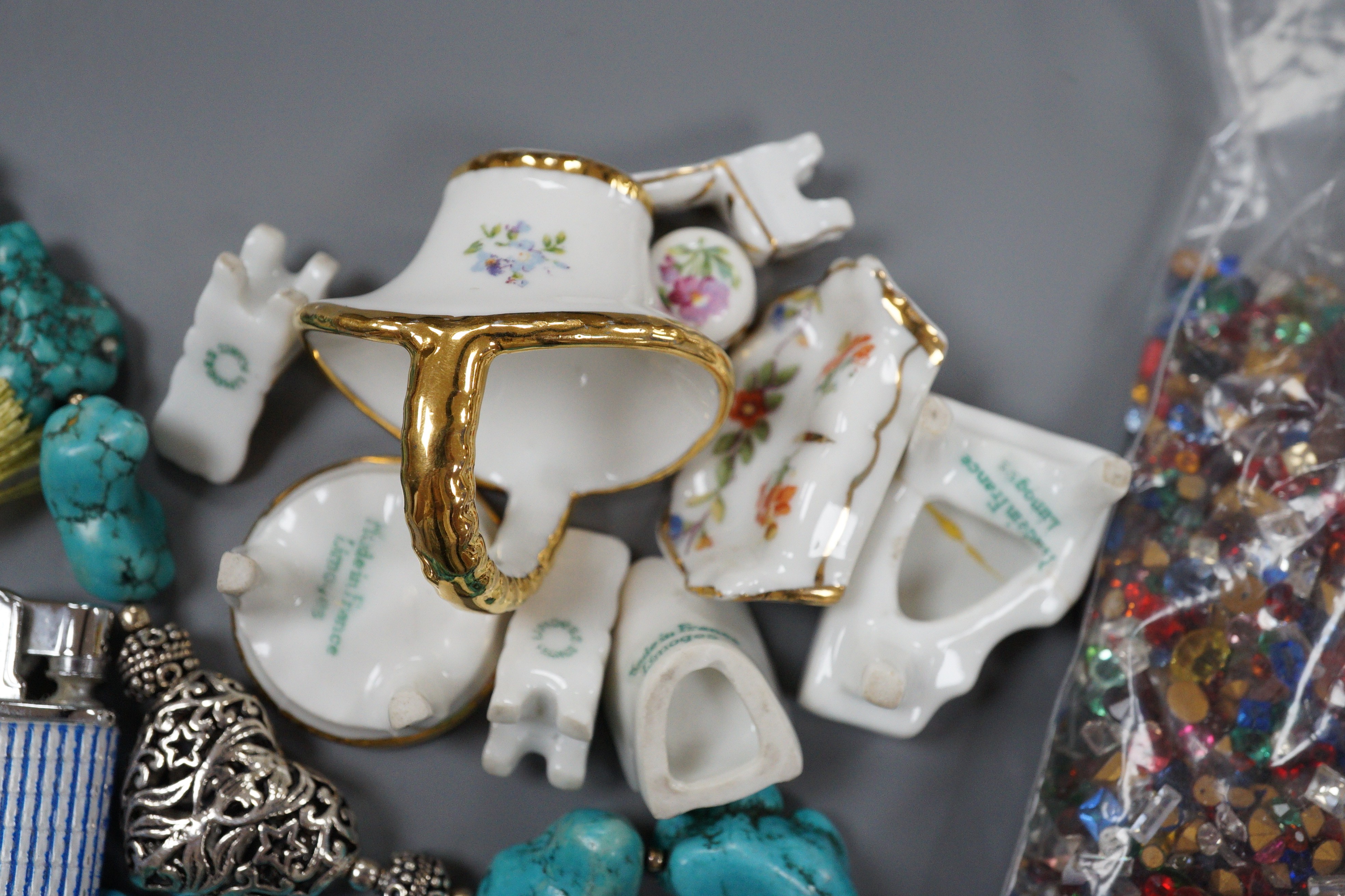 Nine miniature items of Limoges, including furniture, three turquoise necklaces, a group of assorted loose coloured paste stones and four assorted lighters.